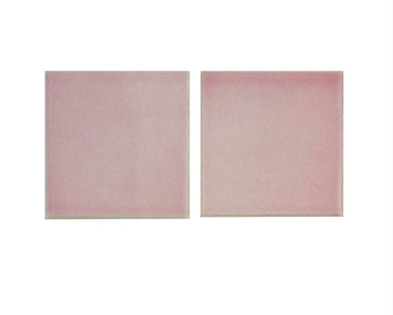 Two pink tiles with a subtle pattern on a white background